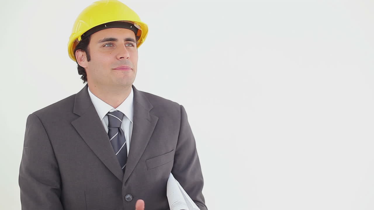 un hombre de negocios sonriente leyendo planos.