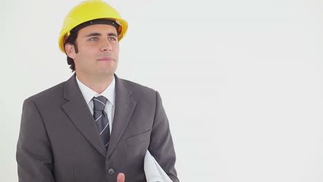 Smiling businessman reading blueprints