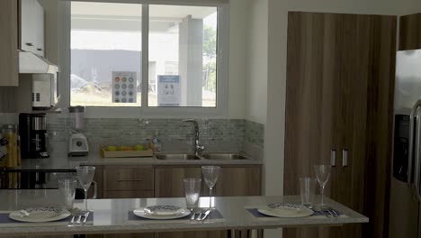 kitchen by the window with microwave faucet glasses cups plates