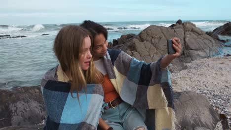 Seitenansicht-Einer-Kaukasierin-Und-Eines-Mädchens-Gemischter-Abstammung,-Die-Ein-Selfie-Am-Meer-Machen