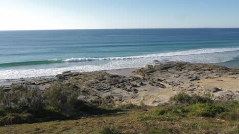 beautiful blue waves rolling to the rocky beach - buddina port cartwright lighthouse - sunshine coast australia - slow motion