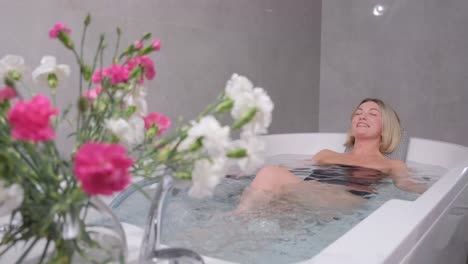 young woman in a swimsuit relaxing while sitting in a hot tub in a luxury spa. happy woman in bath, relaxing hydrotherapy in beauty center.
