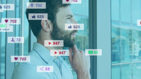 Animación-De-íconos-De-Redes-Sociales-Contra-Un-Hombre-Caucásico-Reflexivo-Mirando-Por-La-Ventana-En-La-Oficina