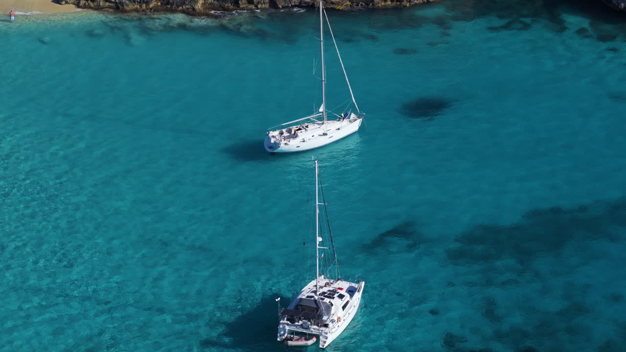 Yacht di lusso ancorati nelle acque cristalline della Laguna Blu nell'isola di Comino, Malta. Ripresa aerea.