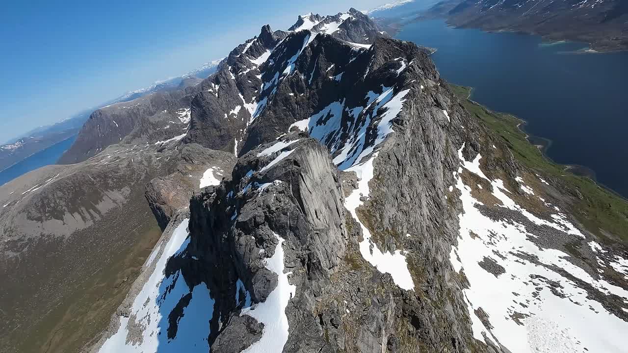 fpv 드론이 하늘을 날아다니며 노르웨이 북부의  ⁇ 빛이 빛나는 산맥의 경치적인 아름다움을 탐색하면서 아드레날린의 충격을 경험하십시오.