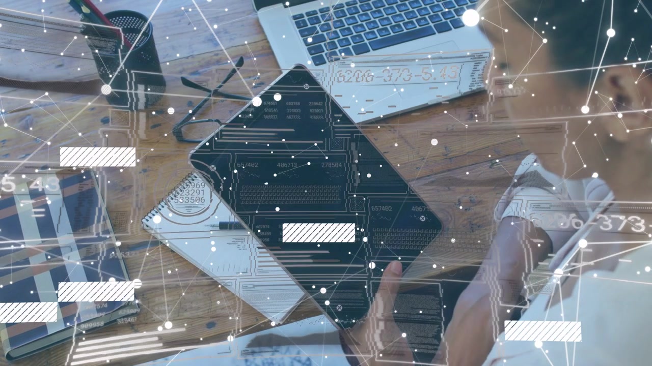 Kvinde rækker ud efter tablet og trykker på skærmen, overlay skifter over skrivebordet, mens hun tjekker laptop-teknologi
