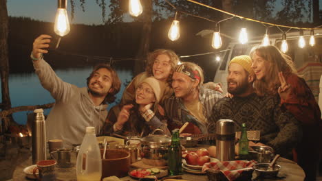 Cheerful-Friends-Talking-Selfie-with-Phone-at-Campsite-in-Evening