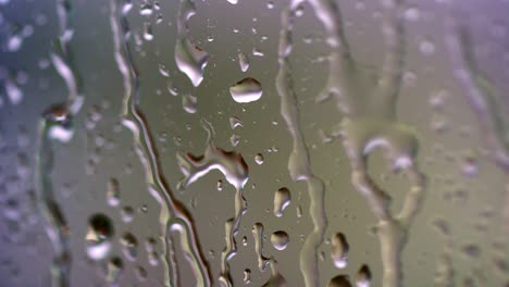 water drops on glass. large rain drops strike a window pane during a summer shower. pure rain drops.