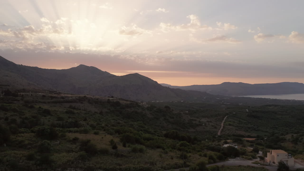 foto de pedestal aéreo das montanhas de creta, na grécia, ao pôr do sol com uma villa solitária em primeiro plano