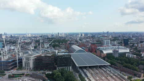 Group-of-cranes-on-construction-site-next-by-St-Pancras-train-station.-Aerial-panoramic-view-of-city-with-modern-skyscrapers-in-distance.-London,-UK