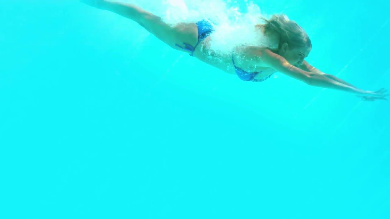 Donna in forma che si tuffa in piscina