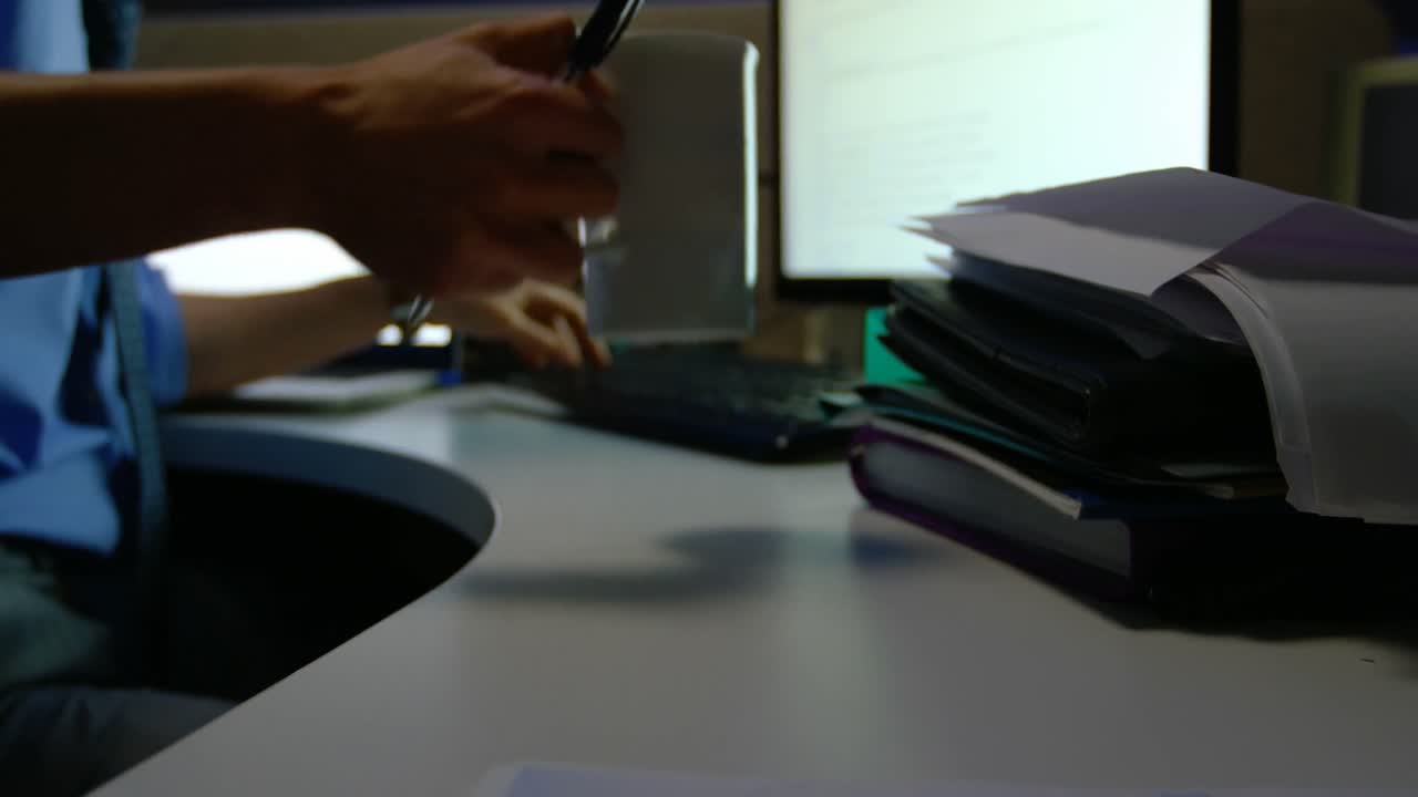 uomo d'affari che beve caffè mentre lavora al computer alla scrivania 4k