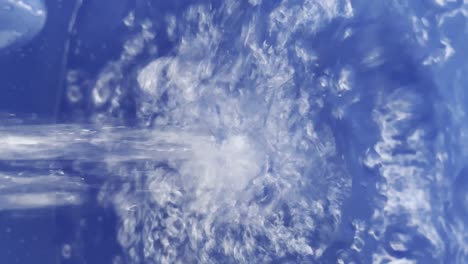 close up view of water splashing filling up blue bucket