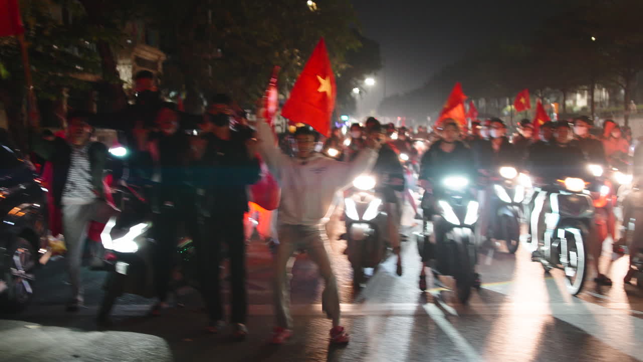 Parata di motociclette con bandiere vietnamite di notte