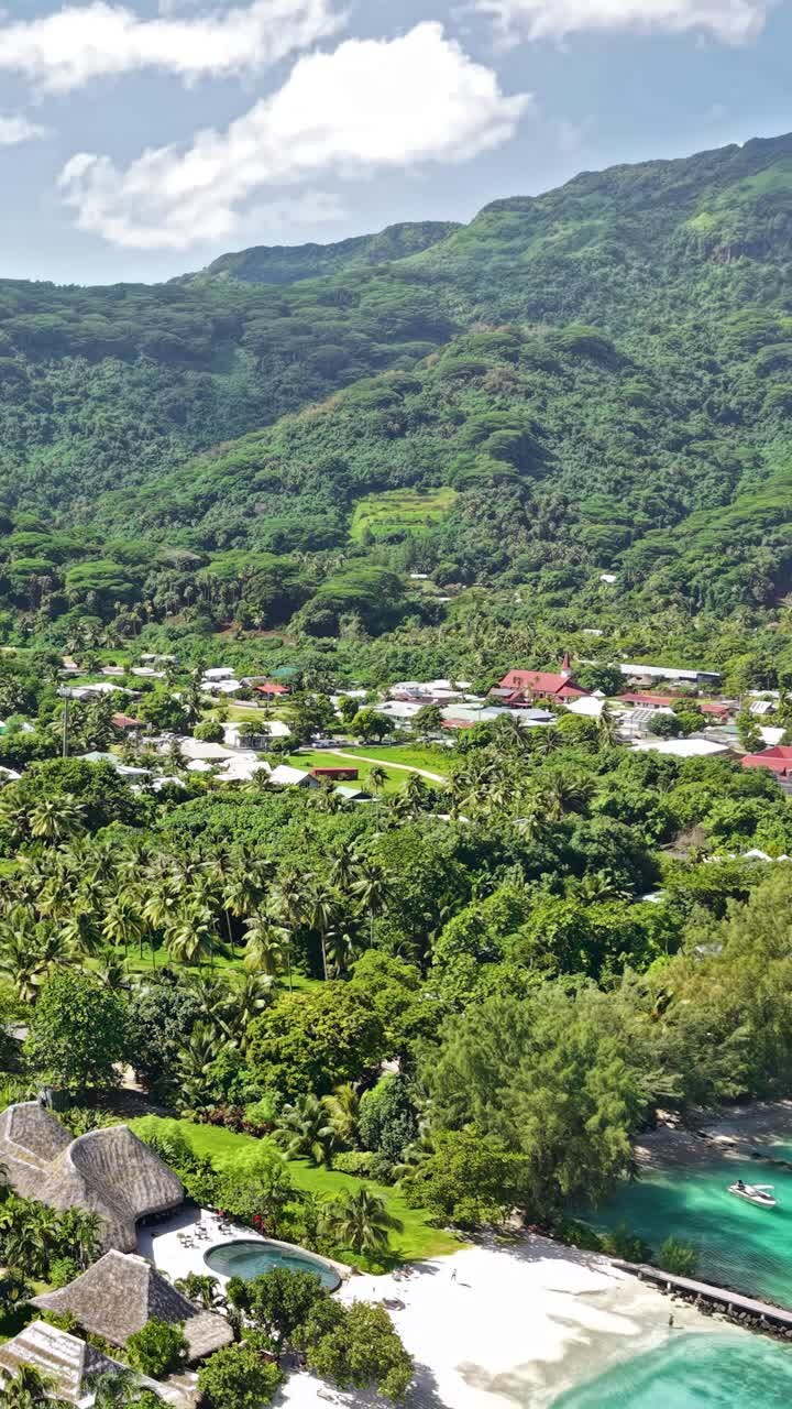 Ripresa aerea verticale con drone dell'isola di Huahine, Polinesia Francese. Ville ed edifici nel villaggio di Fare