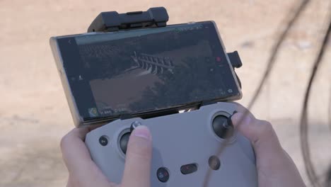 primer plano de un dron de control remoto con una vista de una presa en un río