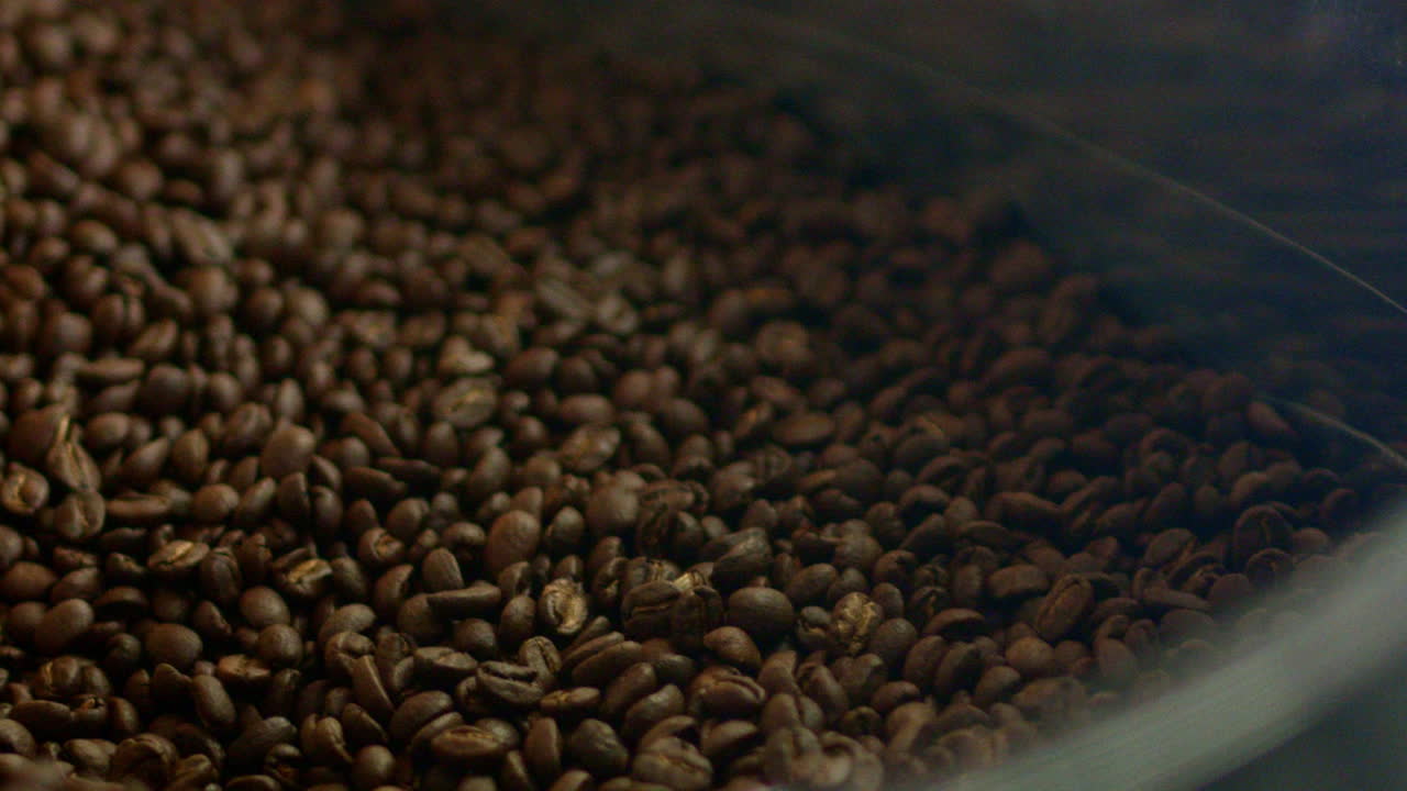 The coffee roasting process. Organic freshly roasted coffee beans being cooled. How coffee is made.