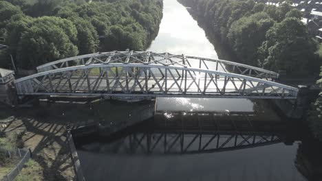 scenic old-fashioned steel arched traffic footbridge rising above manchester ship canal at sunrise