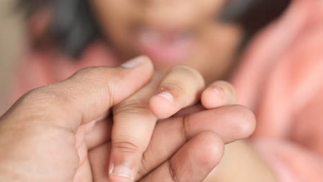 a child's hand being held by an adult