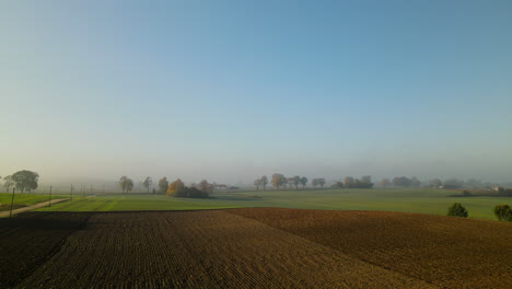 Misty-beautiful-farmlands-of-Napromek,-Poland--aerial