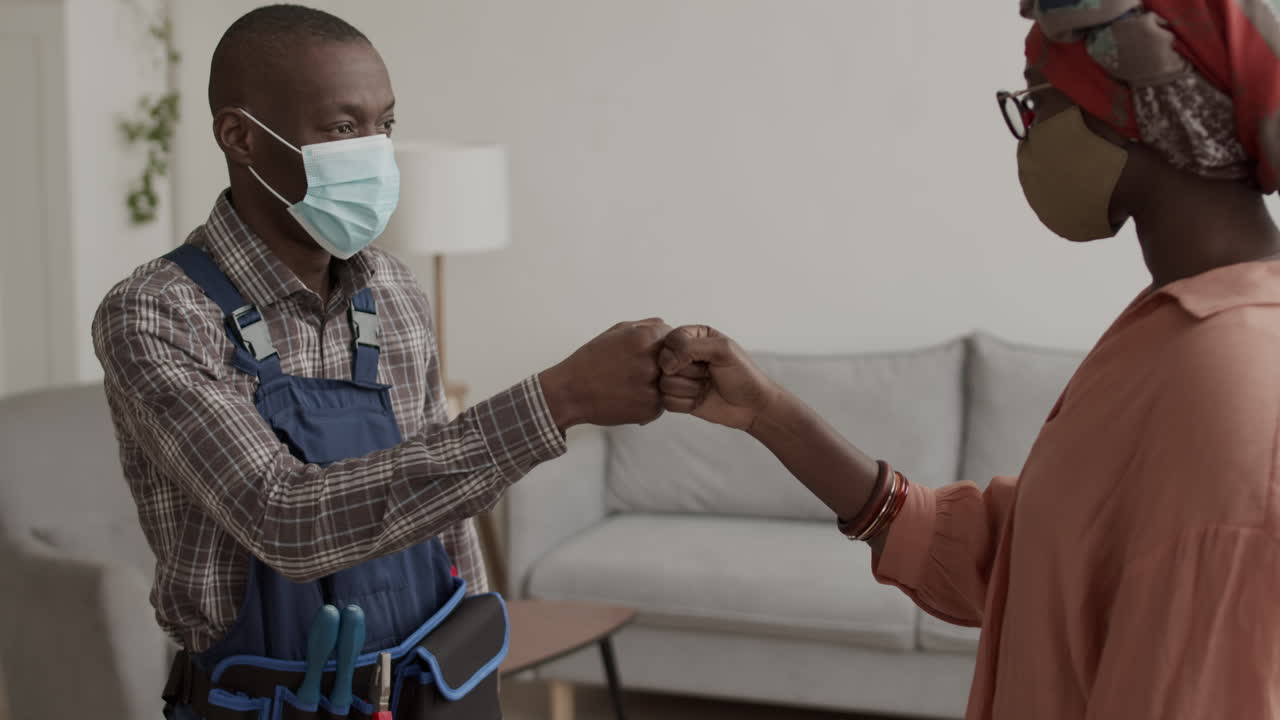 African-American Woman Wearing Mask Telling Handyman What to Do