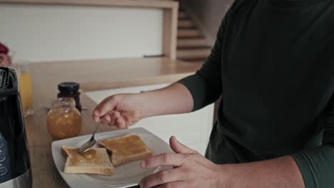 adult caucasian man with down syndrome preparing breakfast.