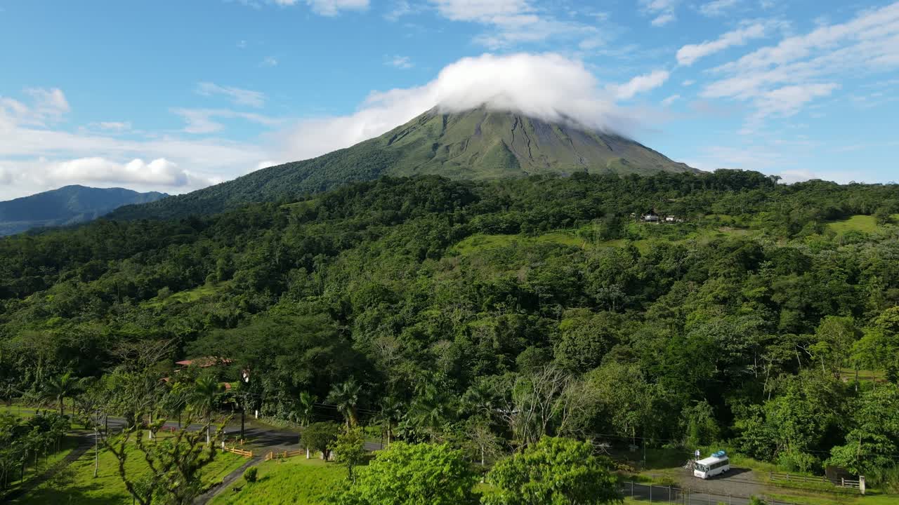 Aerial view moving forward shot, Scenic view of the landscape on the foothills of the Arena Volcano in Costa Rica, Lenticular clouds on the volcano in the background