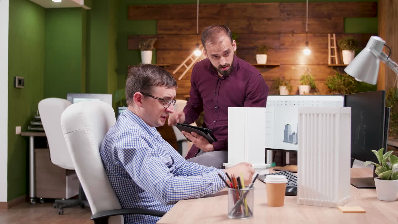 Two men working on an architecture model in an office