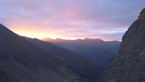 espectacular y colorida puesta de sol en un cielo nublado sobre una cresta de picos montañosos irregulares