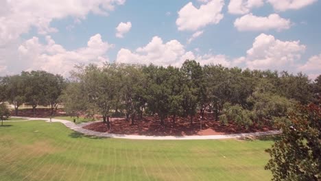 Ascending-aerial-shot-of-Orlando,-with-a-park-beneath-revealing-the-city