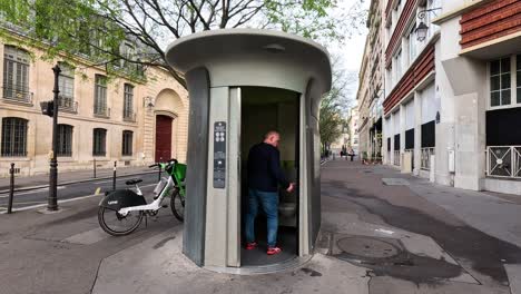 sequence of a man entering and using a street toilet.