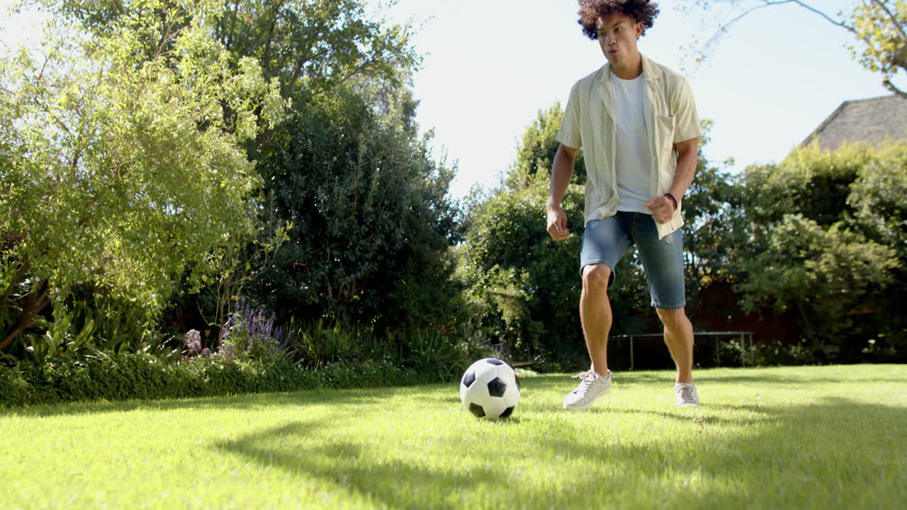 Playing soccer in backyard, man enjoying outdoor activity with soccer ball, copy space