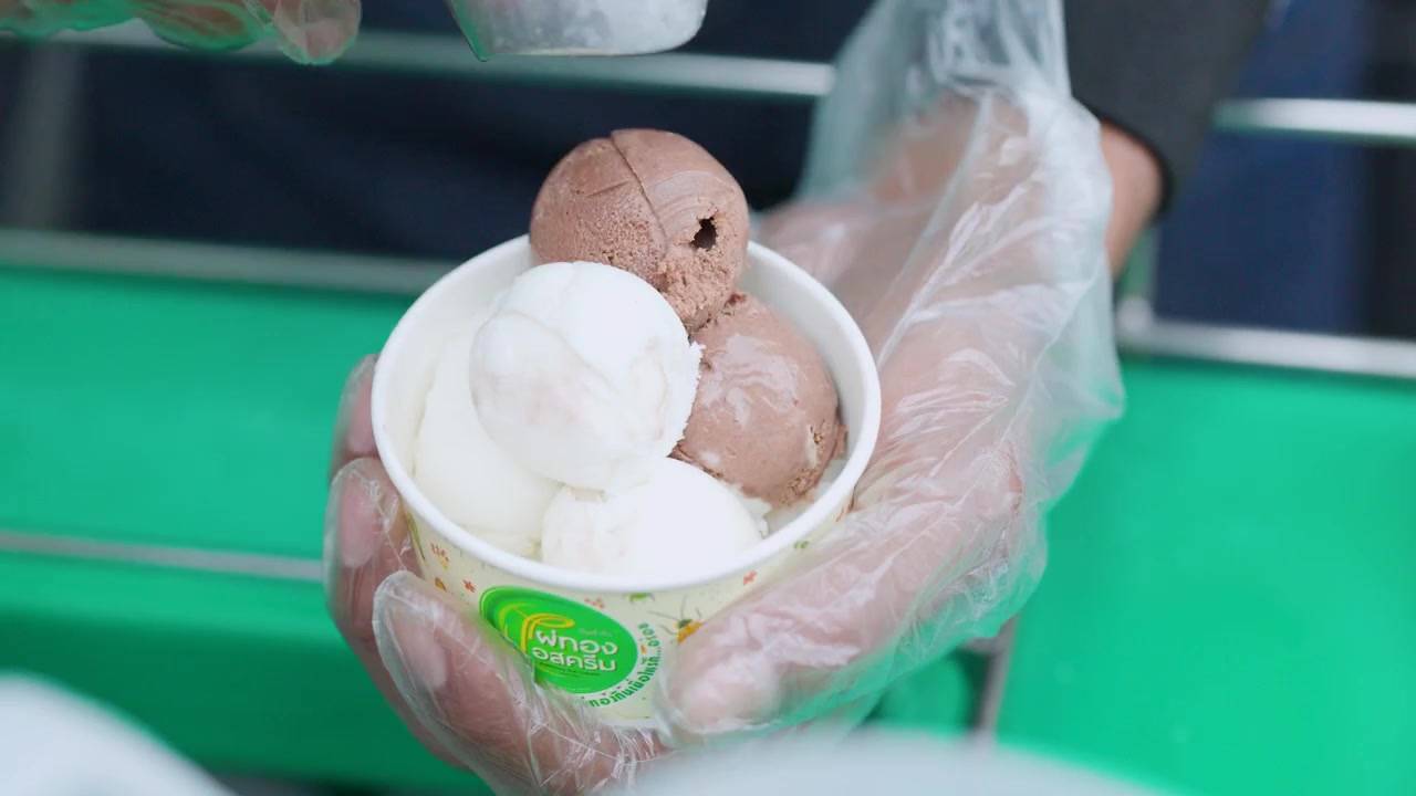 Venditore che serve il gelato in una coppetta di carta