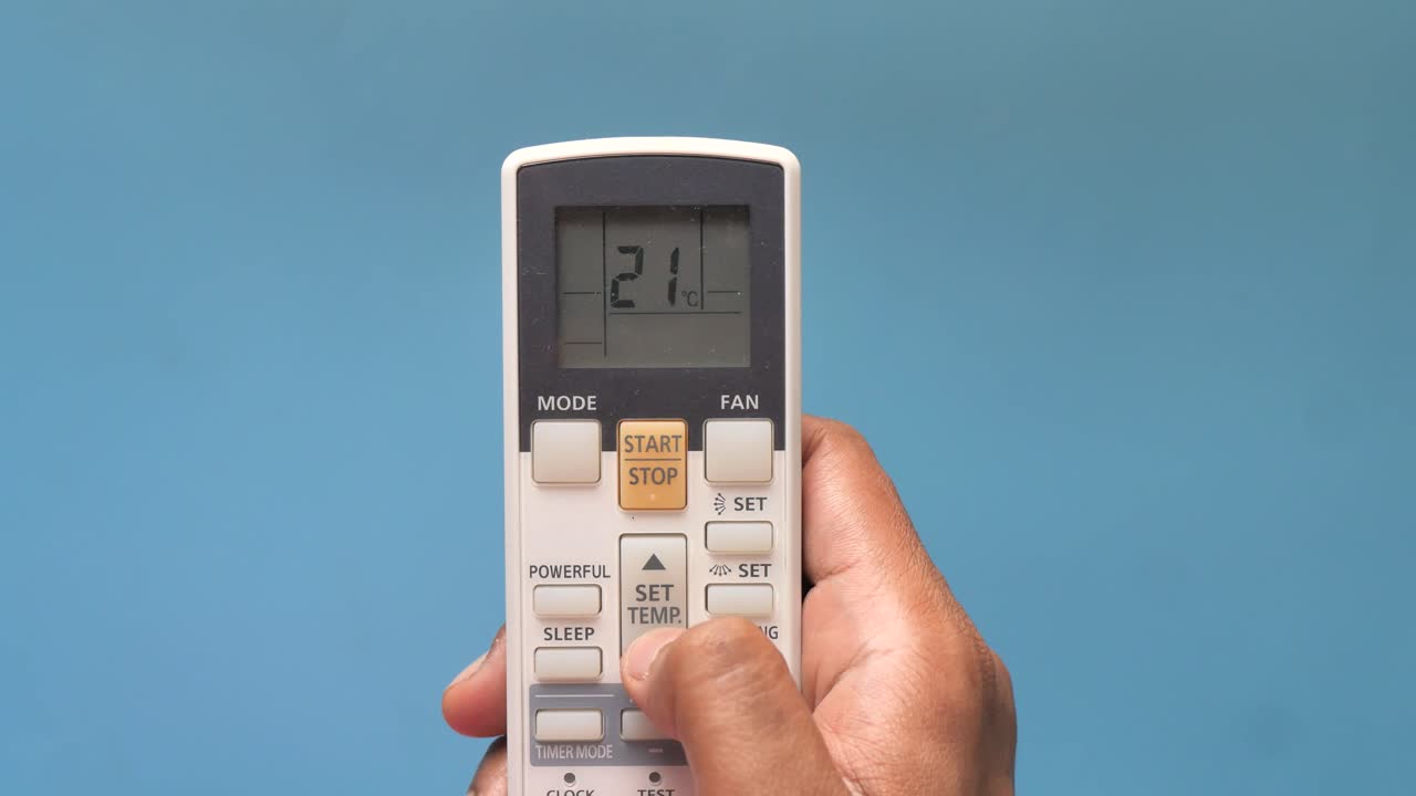Person bruger fjernbetjening til aircondition