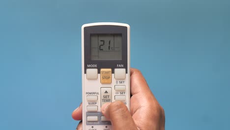 persona que utiliza el control remoto del aire acondicionado