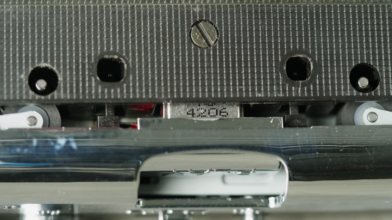 Close-up of a vintage audio cassette tape showing wear marks and magnetic tape reels in retro style.