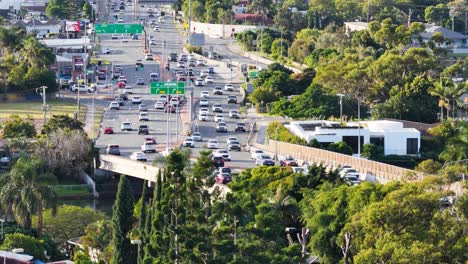 Aerial footage captures busy highway traffic amidst lush greenery and urban landscape in Gold Coast, Australia