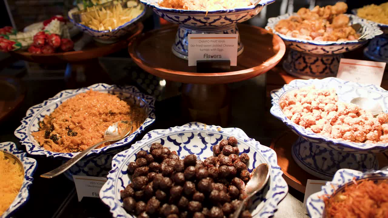 Una lenta carrellata su un elaborato buffet thailandese con riso jasmine e piatti tradizionali.