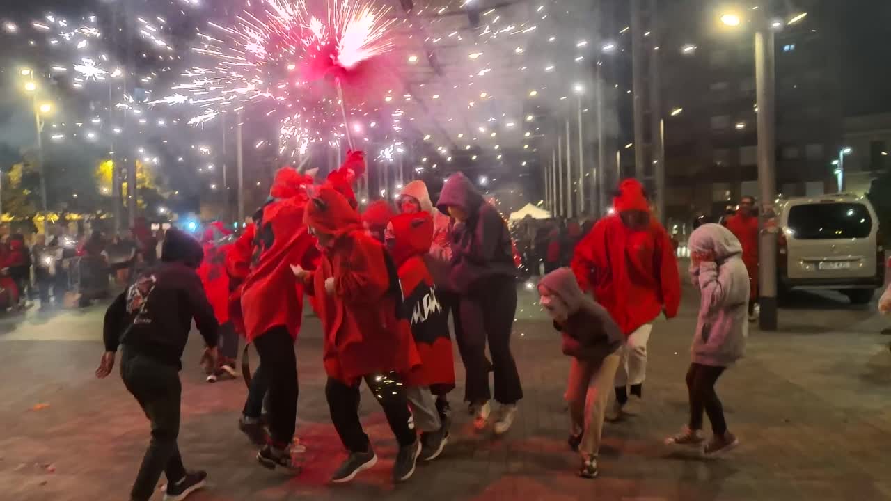 Devil dressed kids walking and dancing under fireworks in Barcelona Spain, Catalunya correfocs traditional holiday