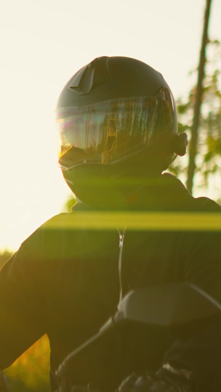 Motociclista Usando Capacete Pilotando ao Pôr do Sol