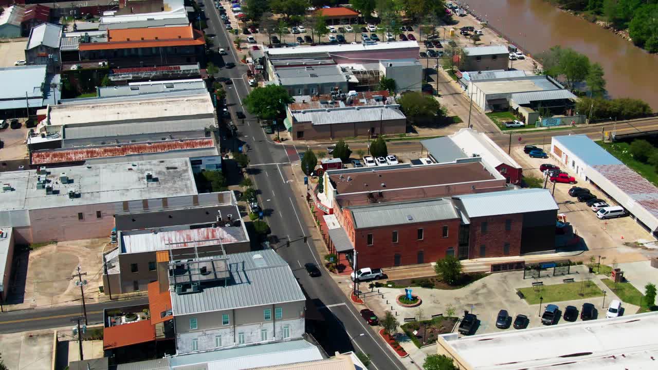 The drone circles above New Iberia’s Main Street, where sunlight glints off Bayou Teche and historic storefronts line the banks beside parks, cafés, and lively southern charm