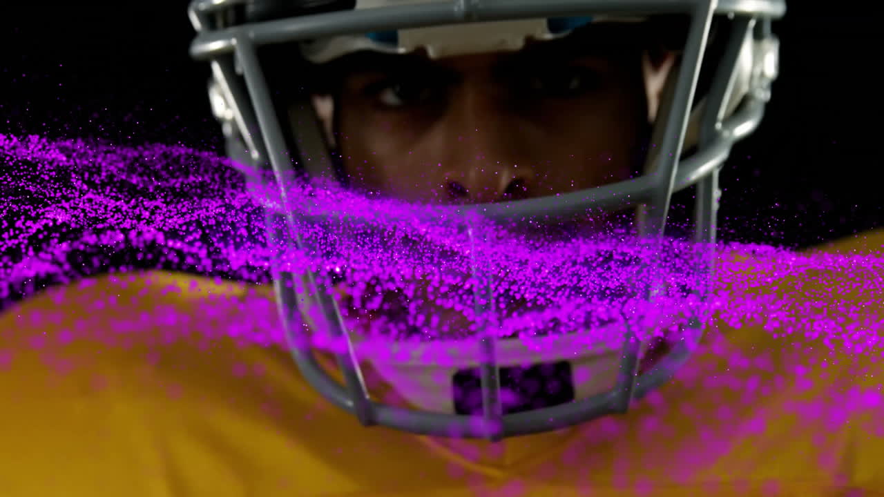 Giocatore di football americano con particelle rosa che vorticano intorno al casco, che indossa una maglia gialla