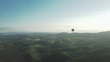 Drone-shot-of-colourful-hot-air-balloon-at-sunrise-over-rolling-tuscany-hills