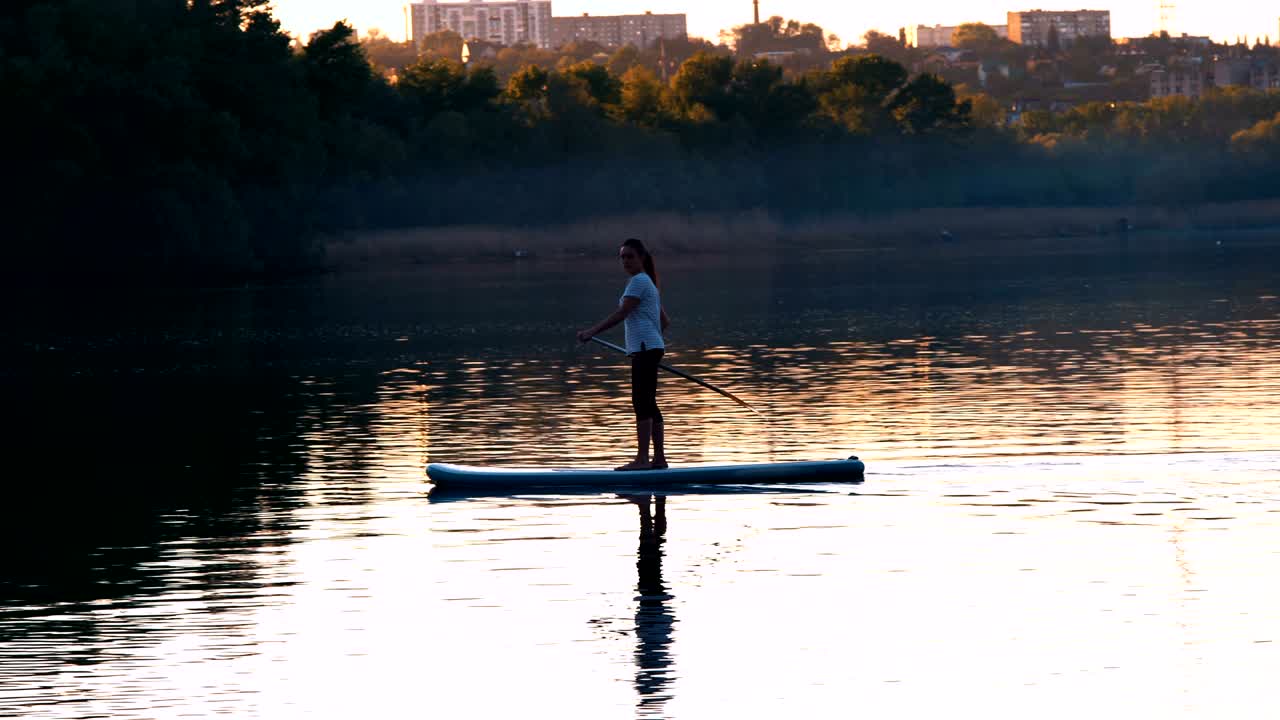 Long Shot, Beautiful Girl with Oars Sails on the River Standing on Sup