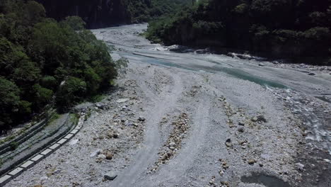 aerial view of a river with very little flow in summer with mountains and abundant vegetation on its banks
