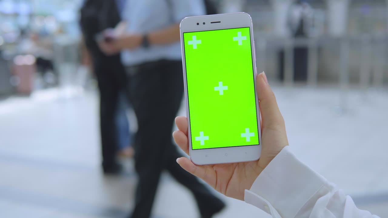 Business woman using smartphone with green screen on the street