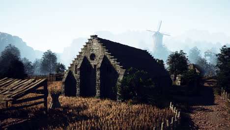 medieval village with stone building and windmill in a foggy landscape