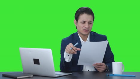 Confused-Indian-manager-reading-and-signing-reports-Green-screen