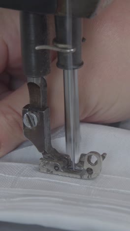 women's hands behind her sewing machine