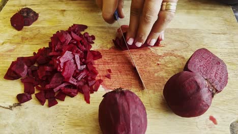 chopping fresh raw beetroot close-up on wood board background studio shot